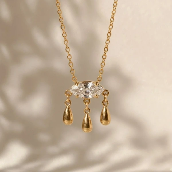 Aurelia Marquise Teardrop Pendant Necklace with a clear marquise stone and three gold-tone drop charms